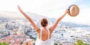 a woman with her arms outstretched in front of a view of a city