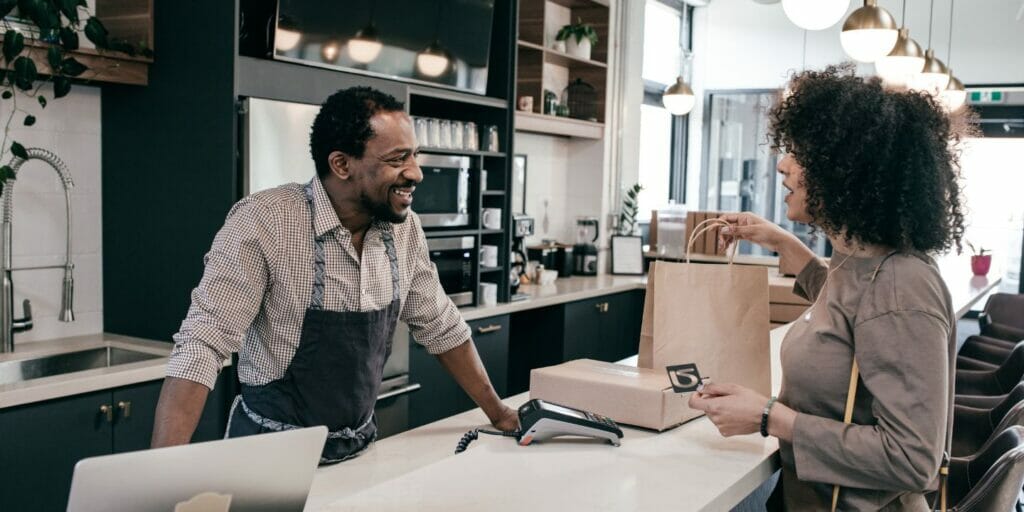 a man and woman standing at the counter of a coffee shop