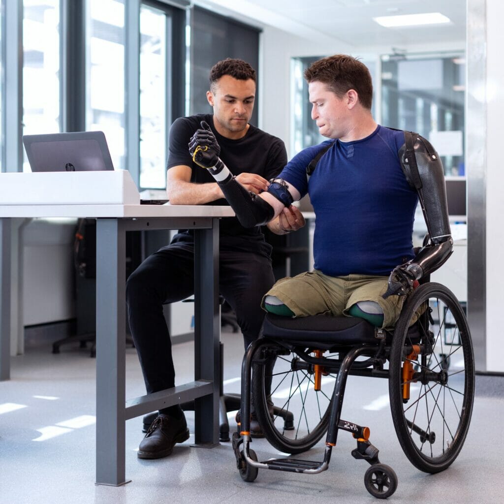 man in wheelchair getting fitted for prosthetic arm