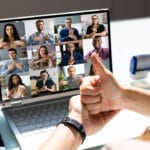 A man having sign language communication over a video conference call with a group of people